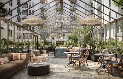 A modern outdoor seating area with wooden furniture and hanging lamps.