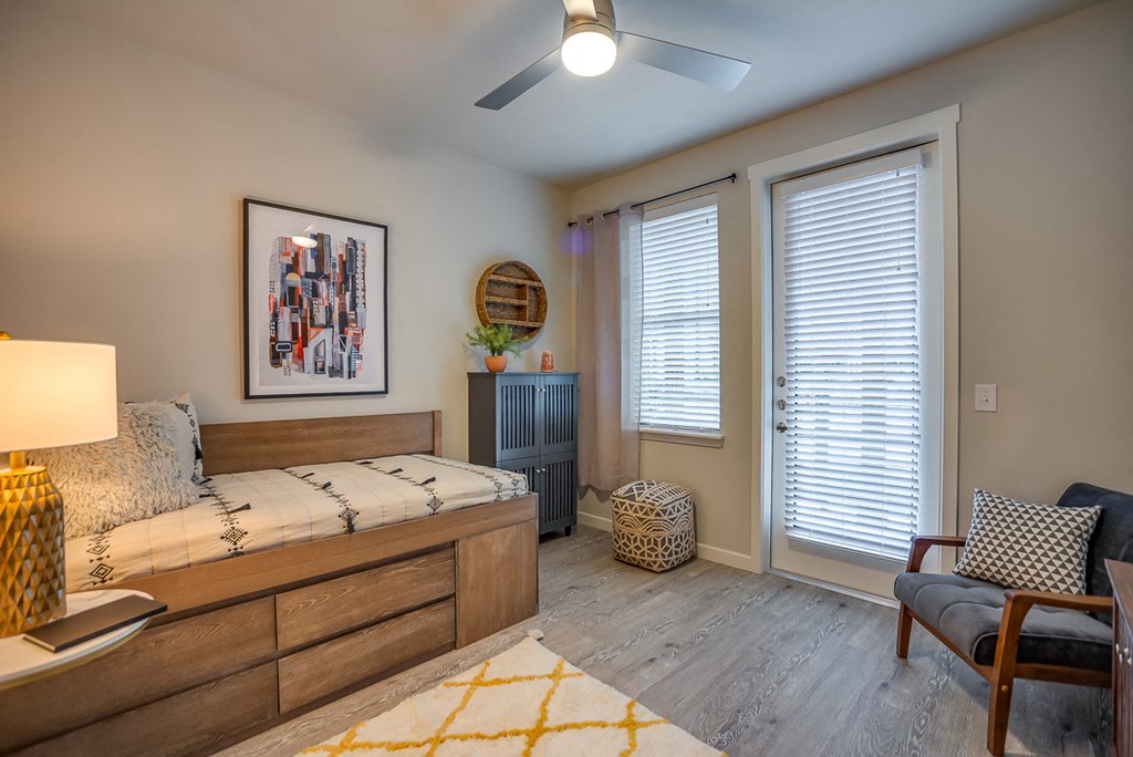 Discovery at the Realm Apartments Living room with ceiling fan and door to balcony