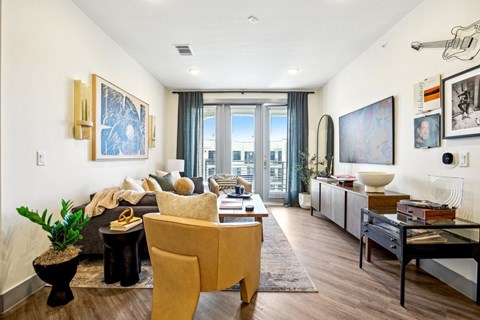 A living room with a yellow chair and a black table.
