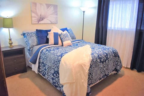 a blue and white bedroom with a bed and a window