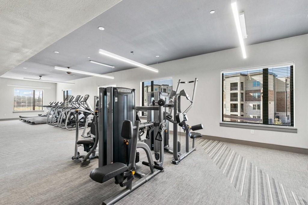 A well-lit gym with a variety of equipment.