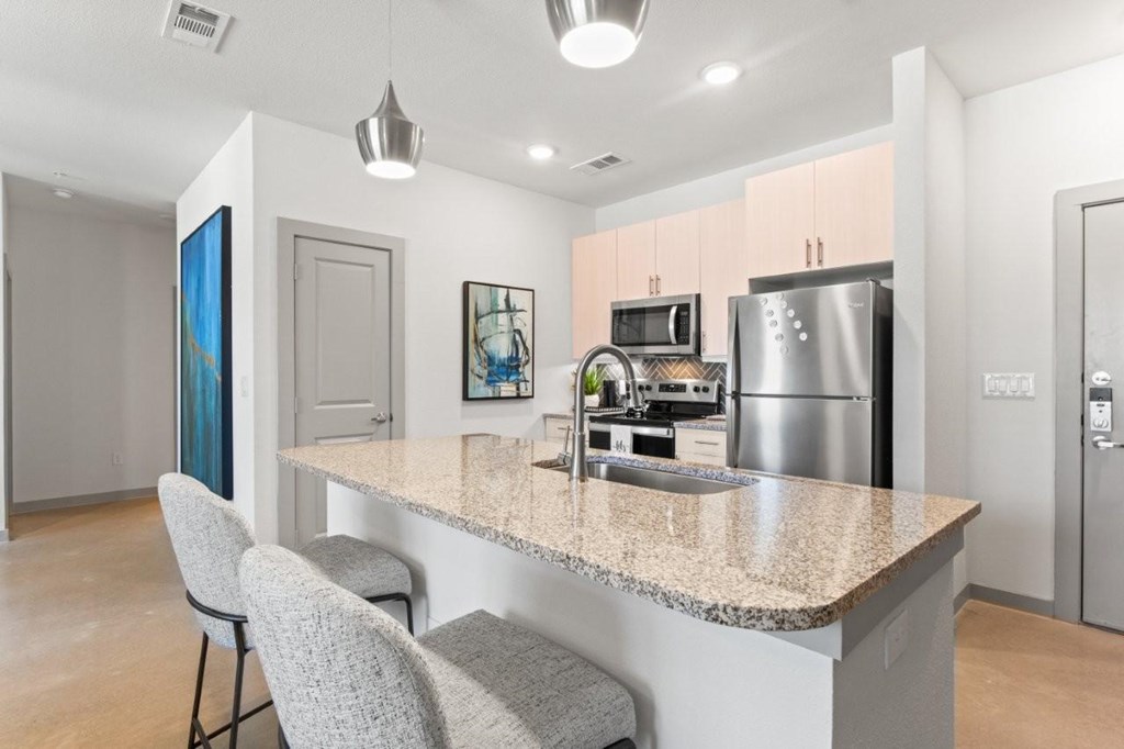 A kitchen with a granite countertop and a refrigerator.