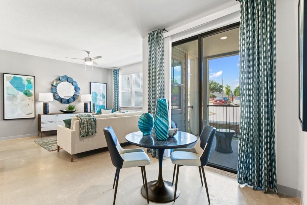 A modern dining room with a glass table and chairs.