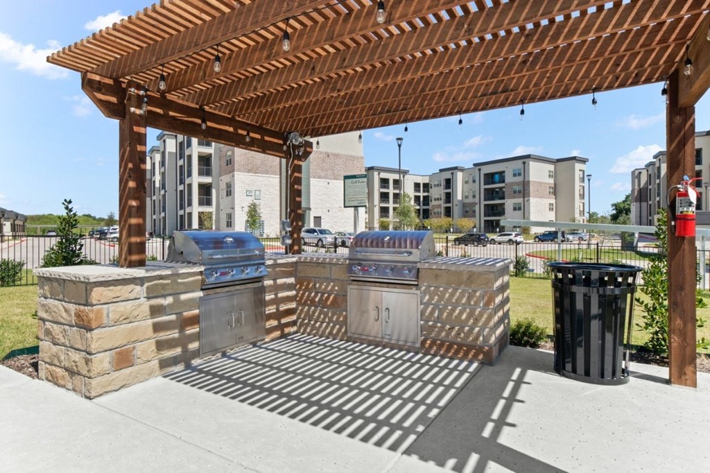 A wooden pergola with a trash can and a fire hydrant.
