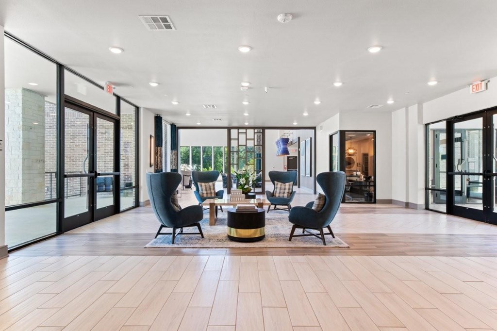A spacious lobby with wooden floors and modern furniture.