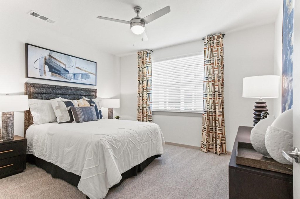 A bedroom with a large bed and a painting above it.