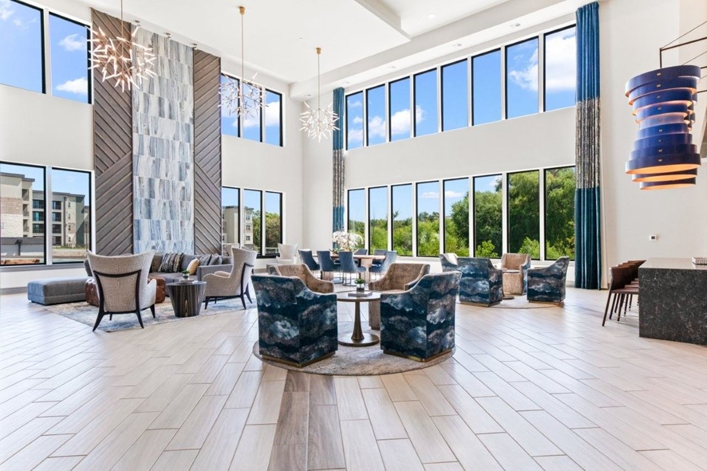 A large, modern lobby with a stone pillar and a large circular table.