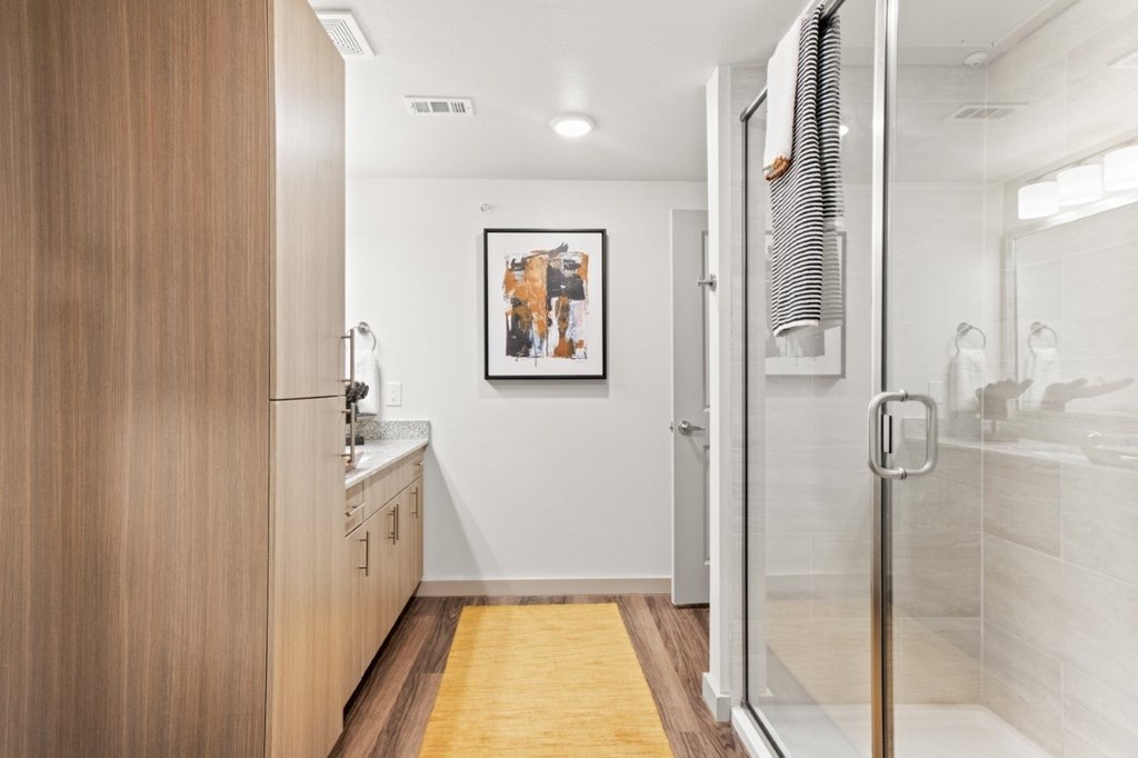 A bathroom with a wooden vanity and a shower.
