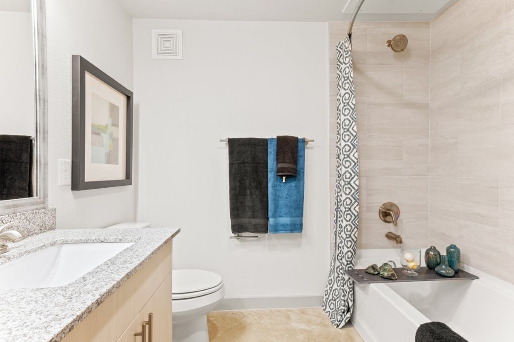A bathroom with a white sink and a white toilet.