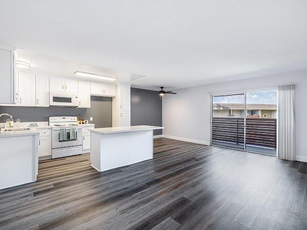 A spacious kitchen with white appliances and a large island.