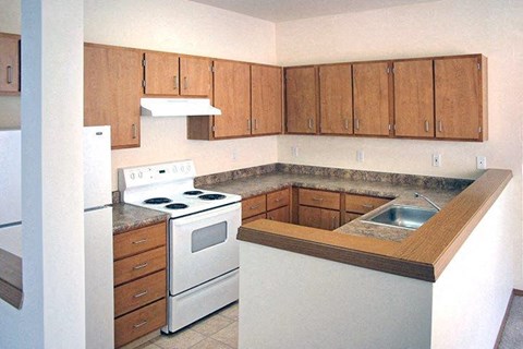 a kitchen with white appliances and wooden cabinets