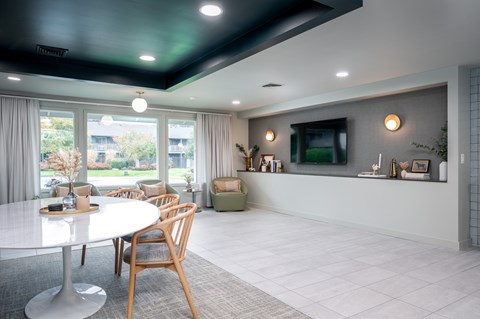 A modern dining room with a white table and chairs.
