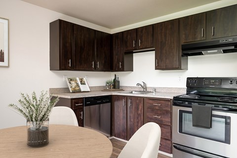 A kitchen with dark brown cabinets and a stainless steel oven.