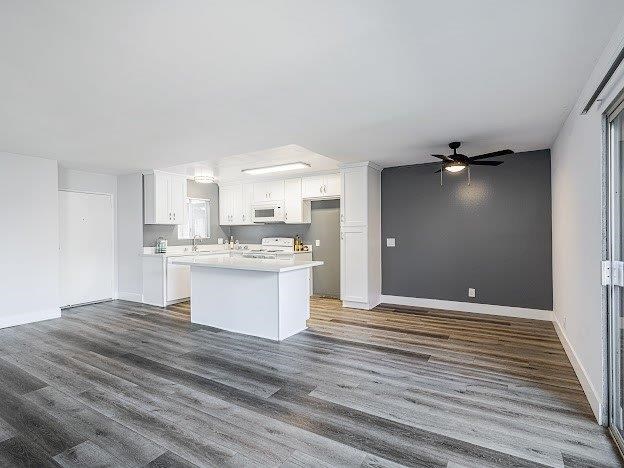 A spacious kitchen with white cabinets and a large island.