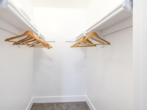 Two wooden hangers are hanging on a white wall.