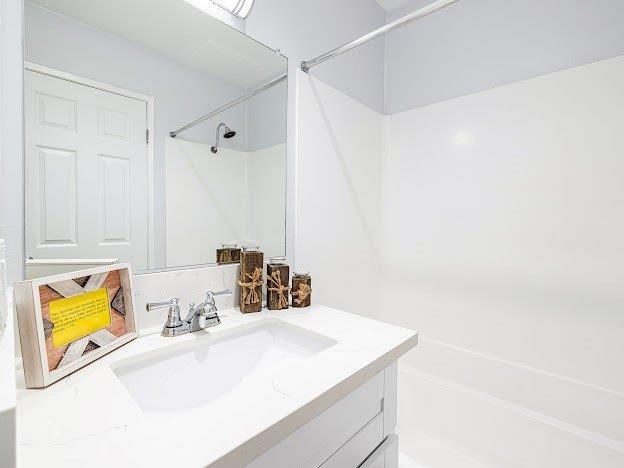 A white bathroom with a sink and a mirror.