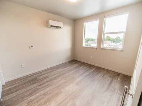 Unfurnished bedroom with laminate flooring and dual windows at Old Town Lofts Apartments, Idaho, 83642
