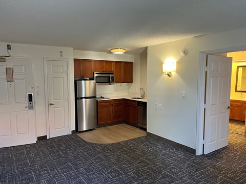A kitchen with a refrigerator, microwave, and oven.