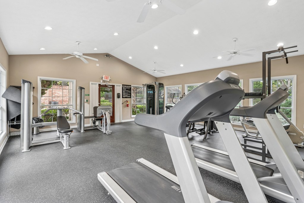 A gym with treadmills, weights, and exercise equipment.