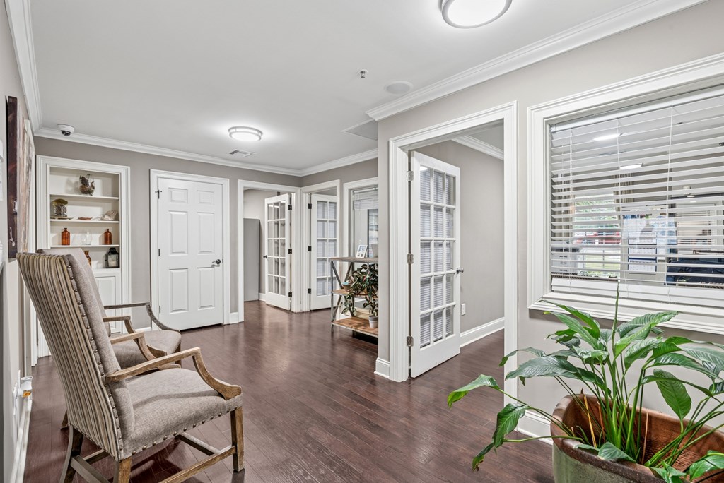 A room with a chair and a potted plant.