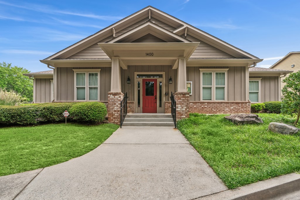 A house with a red door and a stone pillar in front.