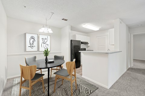 A dining room with a table and chairs.