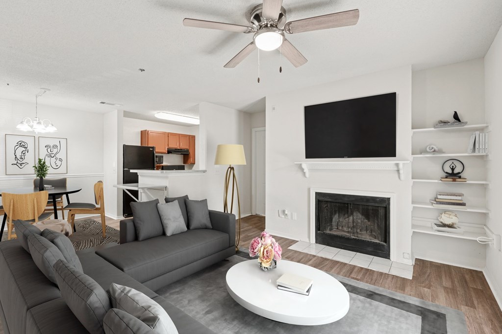 A living room with a grey couch and a fireplace.