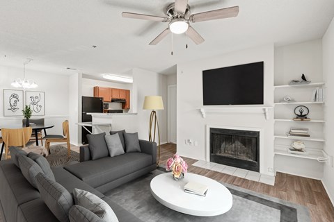 A living room with a grey couch and a fireplace.