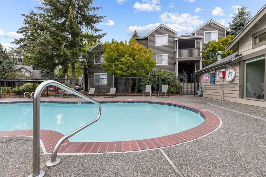 a swimming pool with an apartment building in the background