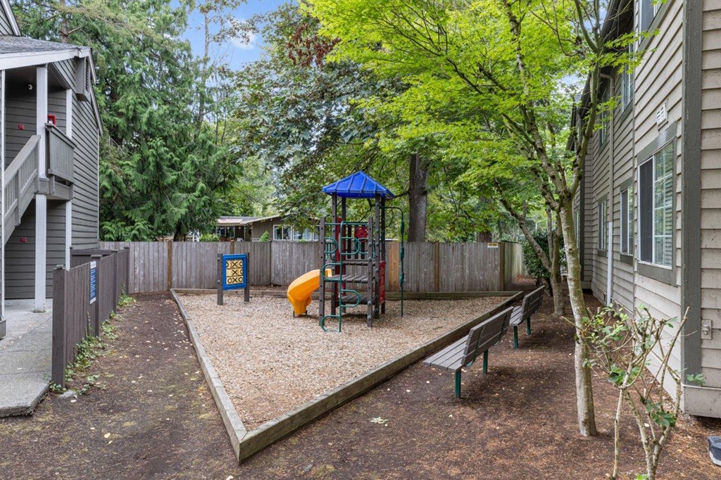 a play yard with a swing set and a playground