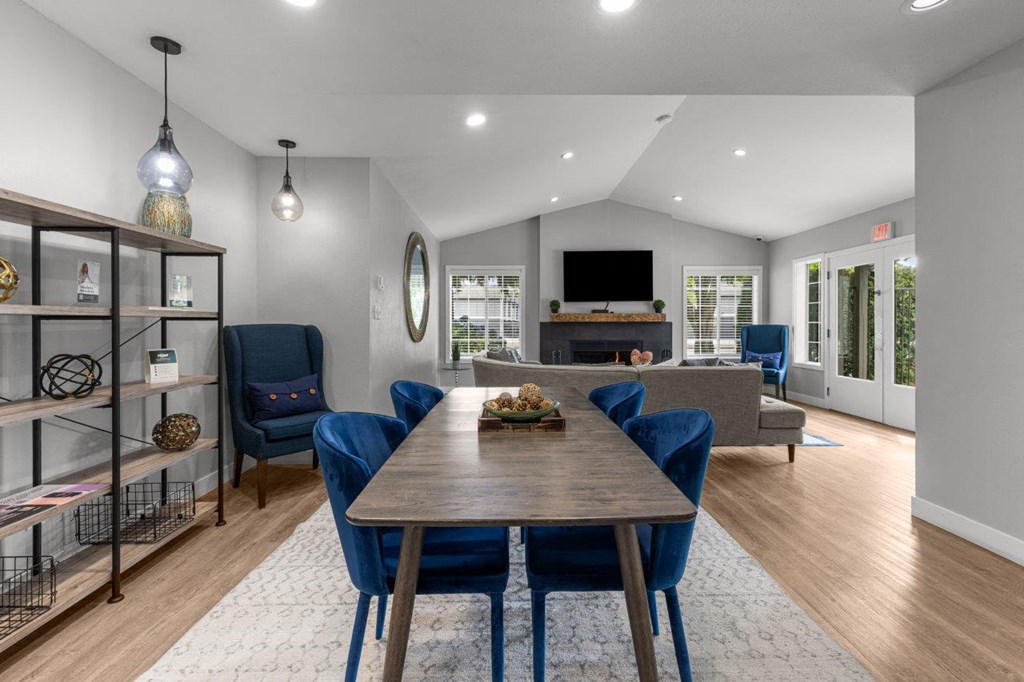 a living room with a wooden table and blue chairs