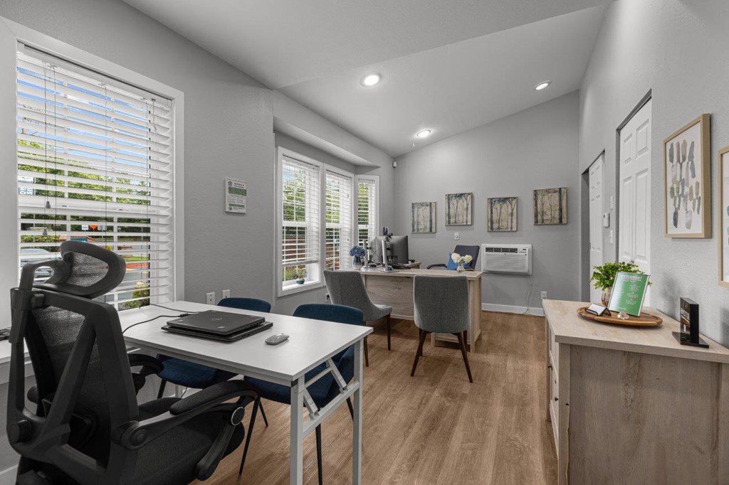 a home office with a desk and a chair and a window