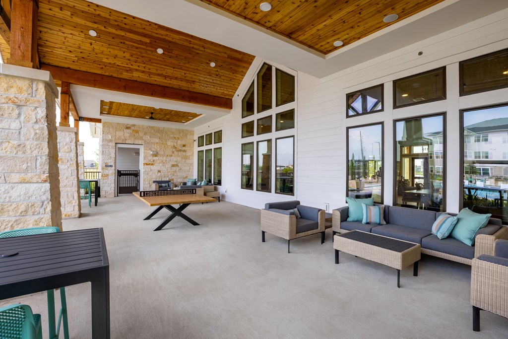a large covered patio with a pool table and couches