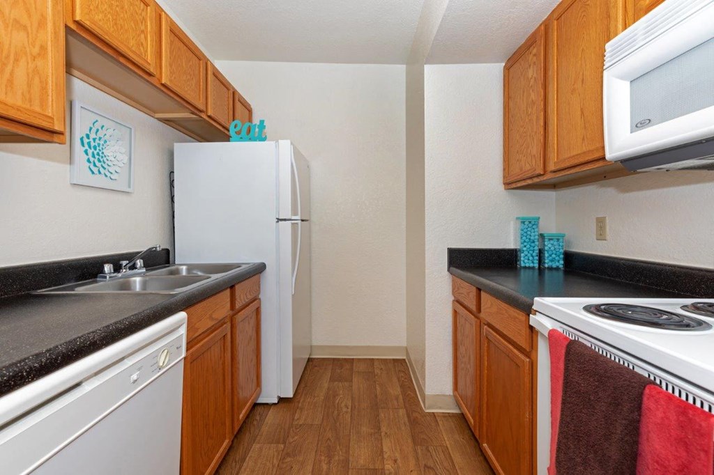 A kitchen with wooden cabinets and a white fridge.