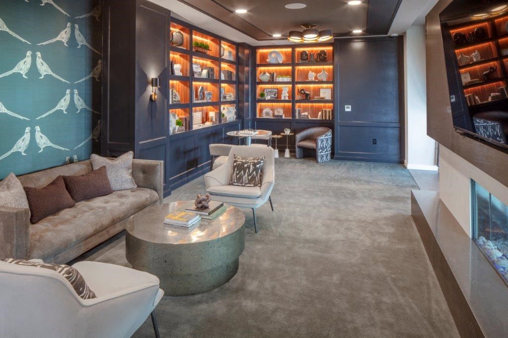 a lounge area with couches and chairs and a wall of shelves