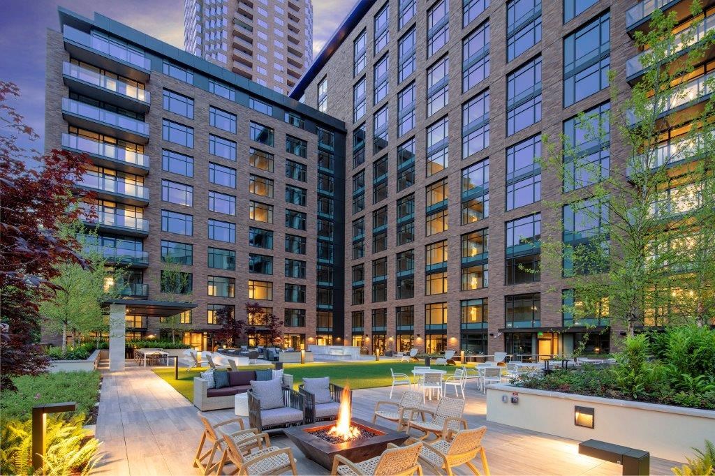 an outdoor lounge area in front of a tall building