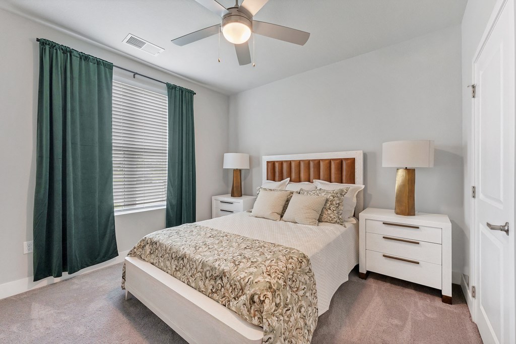 a bedroom with a bed and a ceiling fan
