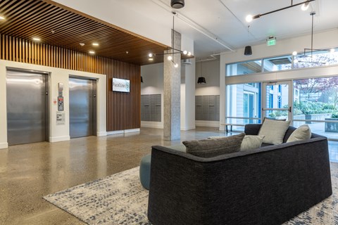 the lobby of a building with a couch and a door