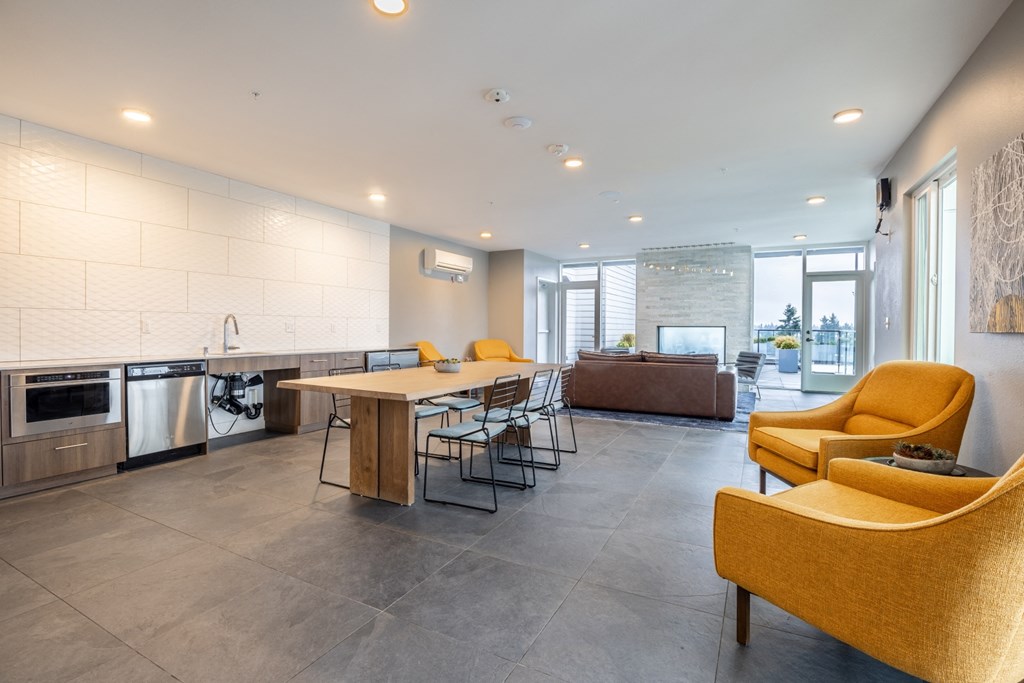 the living room and kitchen of a house with yellow chairs and a table