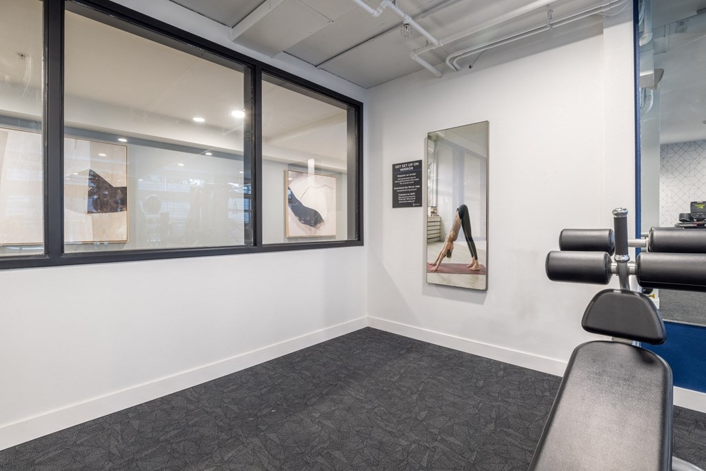 a gym room with exercise equipment in front of a window