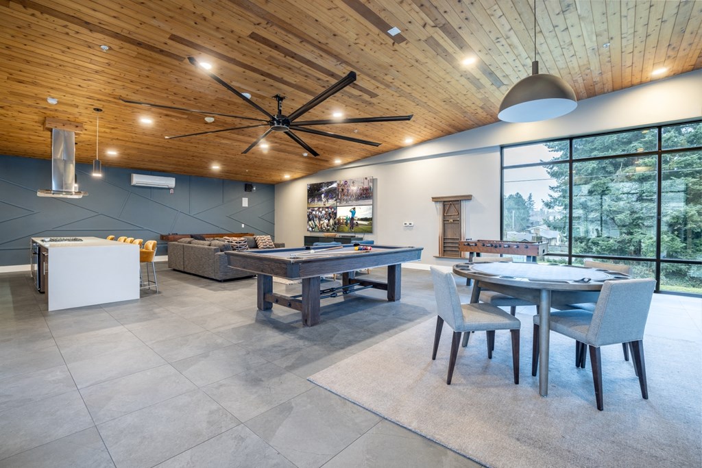 a large living room with a pool table and dining table