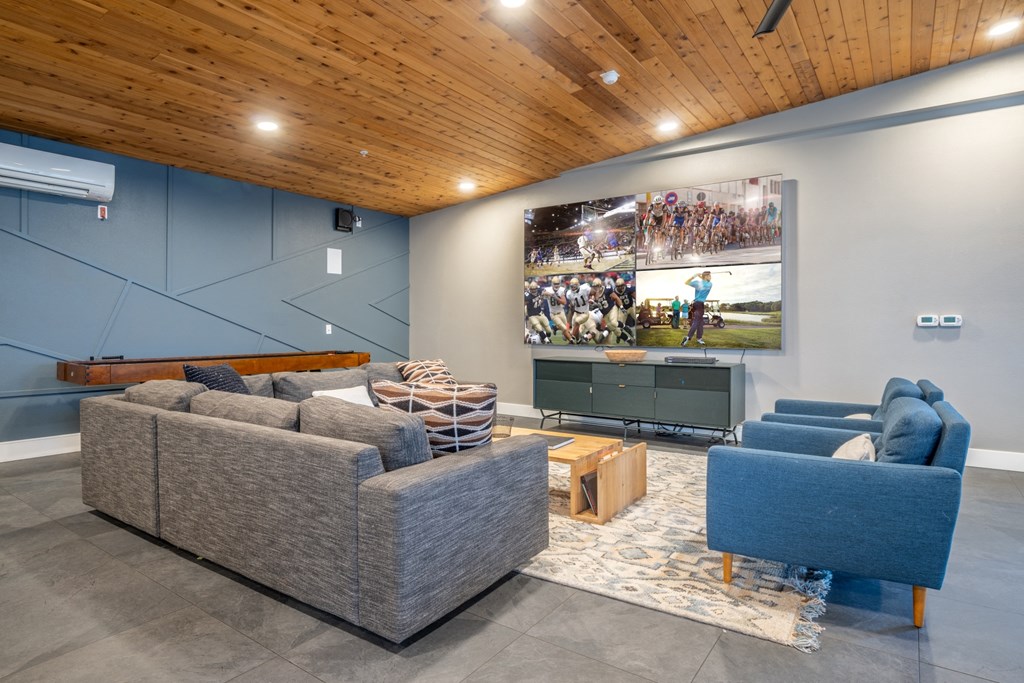 a living room with couches and a tv on the wall