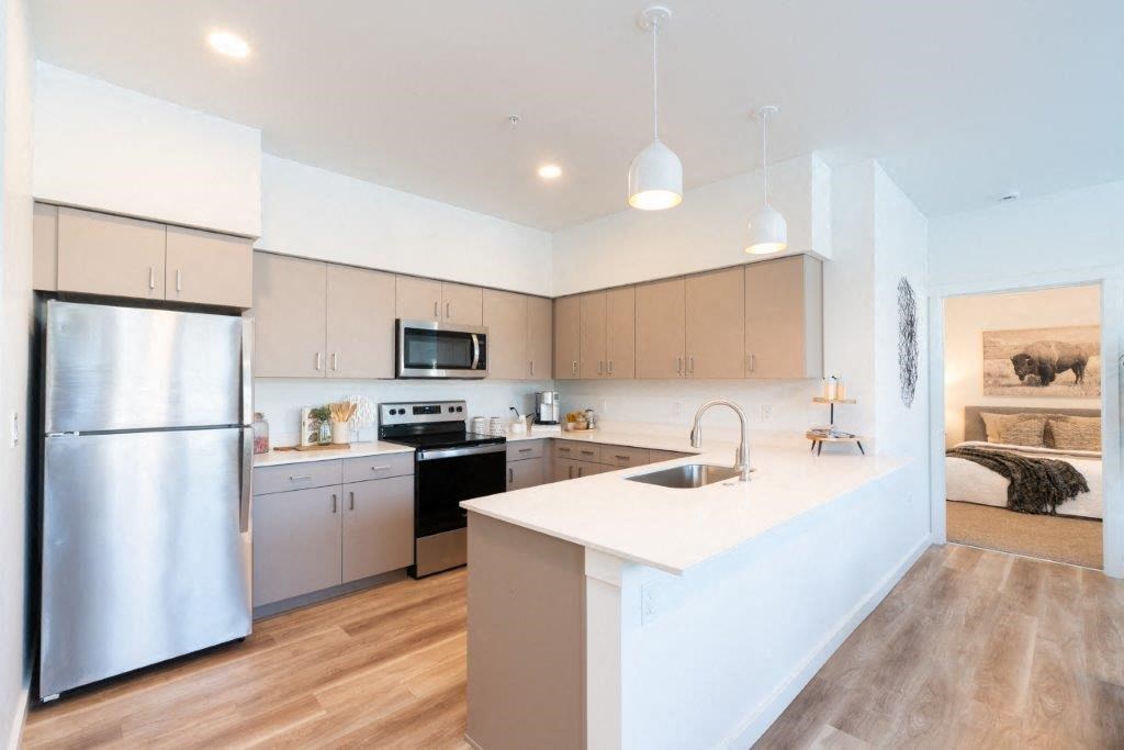 a kitchen with an island and a stainless steel refrigerator