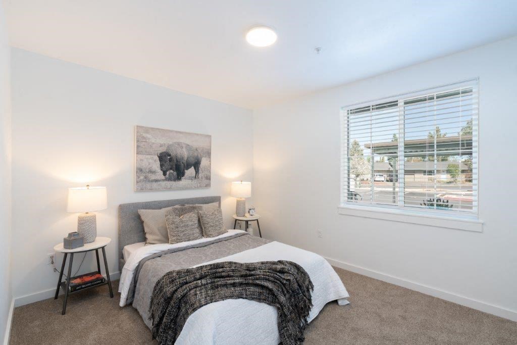 a bedroom with a bed and a large window