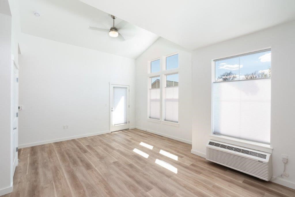 an empty living room with a radiator and a window