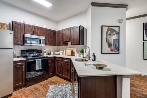 a kitchen with wooden cabinets and a marble counter top