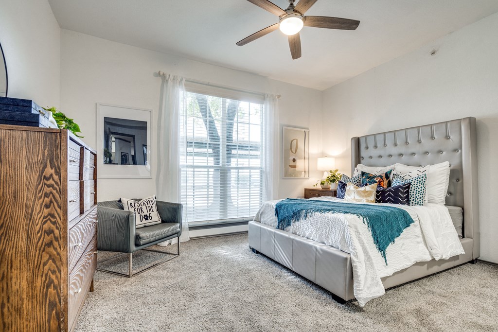 a bedroom with a bed and a ceiling fan