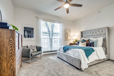 a bedroom with a bed and a ceiling fan