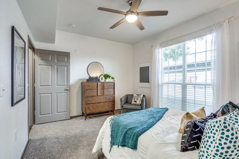 a bedroom with a bed and a ceiling fan