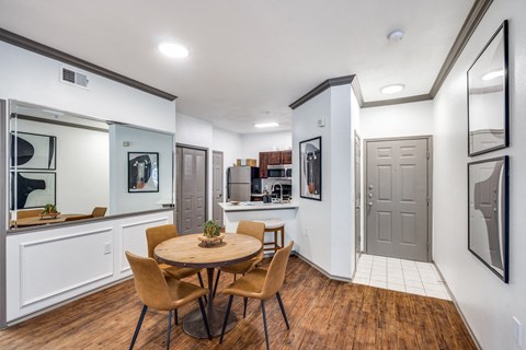 a dining room with a table and chairs and a kitchen